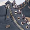 Close-up view of a blue boot, showing details of the zipper, laces, and branding. Voir les images du produit