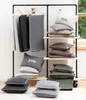 A display of blankets and pillows on a rack and shelves, likely in a store or showroom. Produktbild-Vorschau