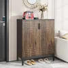 A shoe cabinet with a handbag and flowers on top, placed in an entryway next to a door and a sofa. Voir les images du produit