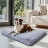 A dog is lying on a gray dog bed in a modern living room with large windows and a sofa. Anteprima dell’immagine prodotto