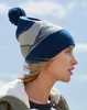 A woman wearing a beanie and jacket against a sky background. Anteprima dell’immagine prodotto