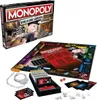 A Monopoly board game set, including the box, board, cards, dice, and handcuffs. Produktbild-Vorschau