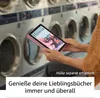 A person is holding a pink tablet in front of a row of washing machines. Produktbild-Vorschau