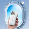 A hand holding a phone with a power bank attached, viewed through an airplane window. Podgląd zdjęcia produktu