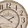 A close-up view of a vintage-style wall clock with Roman numerals and decorative elements. Produktbild-Vorschau