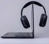 A pair of black headphones is placed on top of an open laptop. Produktbild-Vorschau