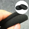 A hand holding black foam ear pads for headphones. Produktbild-Vorschau