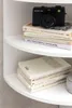 A black Holga camera sits on top of a stack of books on a white shelf. Anteprima dell’immagine prodotto