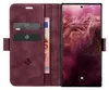 A burgundy flip case for a smartphone, open to reveal card slots and a banknote, with the smartphone screen visible. Produktbild-Vorschau