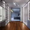 A modern walk-in closet with integrated lighting and a view into a bedroom. Produktbild-Vorschau