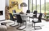 A dining room setting with a table and chairs in front of a window. Produktbild-Vorschau