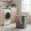 A laundry room with a washing machine and a laundry basket filled with clothes. Produktbild-Vorschau