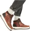 A person wearing dark jeans and gray socks is shown wearing brown winter boots. Anteprima dell’immagine prodotto