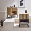 Two contemporary nightstands with a fluted wood-look finish are displayed on a tiered white platform. Produktbild-Vorschau