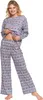 A woman is posing in a grey pajama set with a Nordic pattern. Produktbild-Vorschau
