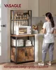 A woman is standing in a kitchen next to a multi-tiered kitchen shelf unit. Produktbild-Vorschau
