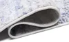 A close-up view of a rolled-up rug, showing the texture and edge binding. Náhled obrázku produktu