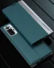 A teal and silver phone case is shown from a diagonal angle on a black reflective surface. Produktbild-Vorschau