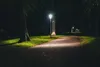 A park path at night, illuminated by streetlights. Produktbild-Vorschau