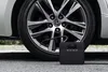 A portable air compressor is connected to a car tire. Produktbild-Vorschau