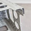 A close-up view of the corner of a gray folding stool, showing the hinge mechanism and rubber grips. Náhľad obrázku produktu