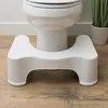 A white toilet stool is placed in front of a toilet on a wooden floor. Podgląd zdjęcia produktu