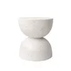 A white speckled hourglass-shaped side table against a white background. Podgląd zdjęcia produktu