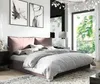 A bedroom scene with a bed, artwork, and a window view. Produktbild-Vorschau