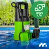 A green and black submersible pump is partially submerged in blue water, with a green hose attached. The background shows lush green foliage and a hint of a swimming pool. Anteprima dell’immagine prodotto