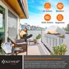 A woman is sitting on a balcony chair reading a book, with a privacy screen in the background. Produktbild-Vorschau