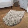A fluffy gray rug is placed on a wooden floor next to a white sofa and a wicker basket. Produktbild-Vorschau