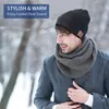 A man wearing a beanie and scarf in a snowy outdoor setting. Anteprima dell’immagine prodotto