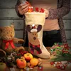 A person is filling a Christmas stocking with gifts, surrounded by festive decorations and treats. Produktbild-Vorschau