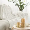A white and gold marble-patterned blanket draped over a sofa, with decorative candles on a tray on a side table. Anteprima dell’immagine prodotto