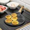 A waffle pan with freshly made waffles on a stovetop. Produktbild-Vorschau
