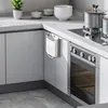 A modern kitchen counter with a hanging trash can, stove, and kitchenware. Produktbild-Vorschau
