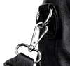 A close-up shot of a black leather bag's strap attachment hardware. Náhľad obrázku produktu