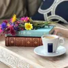 A tray with books, flowers, and a cup of coffee. Produktbild-Vorschau