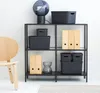 A shelving unit filled with storage boxes and binders, next to a wooden chair. Produktbild-Vorschau