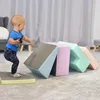 A baby is playing with colorful foam climbing blocks indoors. Podgląd zdjęcia produktu