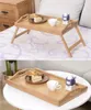 A bamboo tray table with breakfast items on it, shown in two different settings: on a bed and on a coffee table. Produktbild-Vorschau