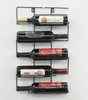 A black metal wine rack mounted on a textured white wall, holding five bottles of wine. Náhľad obrázku produktu