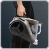 A person holding a compact vacuum cleaner. Produktbild-Vorschau