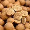 A close-up, shallow depth-of-field shot of many round, brown bait balls, some of which are cut in half to reveal their textured interior. Anteprima dell’immagine prodotto