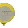 A close-up view of a coin cell battery with a metal clip attached. Produktbild-Vorschau
