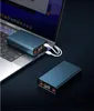 Two power banks are shown, one connected to a laptop, on a dark surface. Náhled obrázku produktu