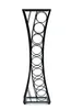 A black metal wine rack with a modern, hourglass-like design, standing against a white background. Podgląd zdjęcia produktu
