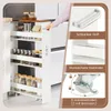 A person's hand is pulling a narrow kitchen cart with shelves out from a gap between cabinets. The cart has jars of spices on its shelves. Insets show details of the cart's handle, shelves, and wheels. Voir les images du produit
