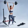 A woman is performing an overhead press with a barbell in a gym setting. Náhled obrázku produktu