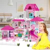 A young girl in a yellow dress is playing with a large pink dollhouse. Voir les images du produit